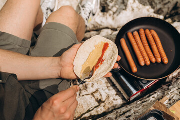Crop traveler cooking flatbread hot dog
