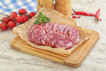 Sliced salami sausages over board