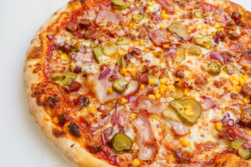 pizza with ham, red onion, corn, cheese and pickles