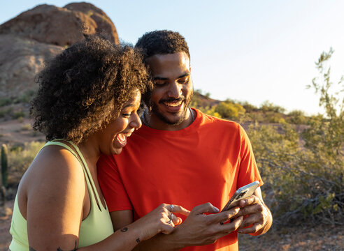 Desert  Arizona Landscape with Gen z friends laughing at smartphone 