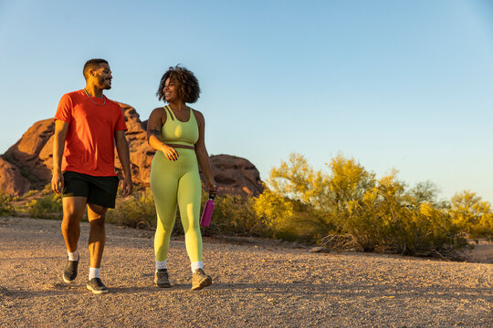 Two Happy African American Friends Hiking Together In Desert Arizona 