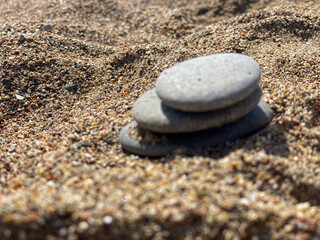 Fototapeta na wymiar Stones lie on yellow sand