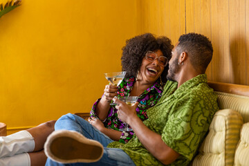 Black Couple laughing together  enjoying martini cocktail at party 