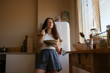 Freckled teen girl eating in kitchen