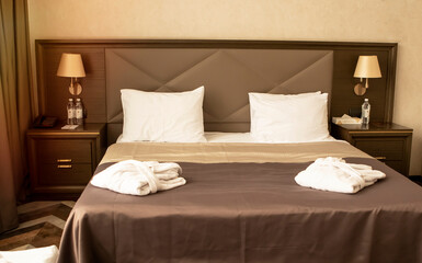 large bed in a hotel room with bathrobes