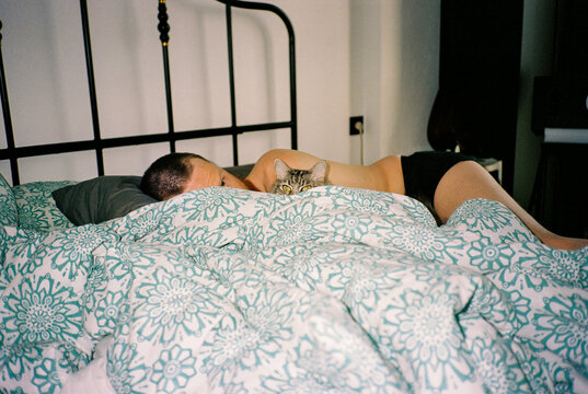 Young man rest in bed with cat