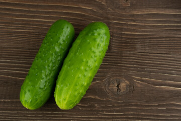 Two cucumbers in close-up on a wooden background. And a place for the inscription.