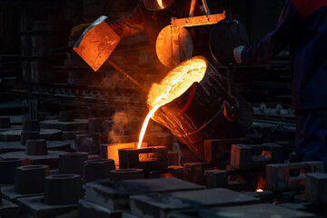 Liquid metal or cast iron poured into molds. Metal casting process with red high temperature fire...