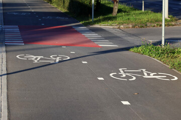 Ścieżka dla rowerów w mieście ze znakami poziomymi.  - obrazy, fototapety, plakaty