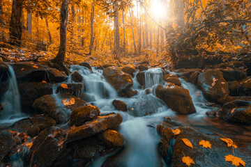 A Tennessee waterfall is illuminated by romantic sunlight during autumn in the Smoky Mountains.