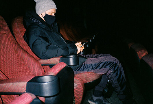 Young man in mask in cinema