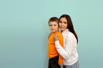 portrait of a little boy with mom on a blue background copy space. mother with a child. happy motherhood and childhood. motherhood and childhood