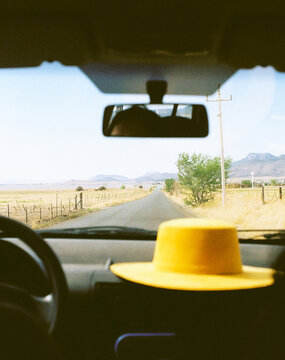 a yellow hat placed on the dashboard car 