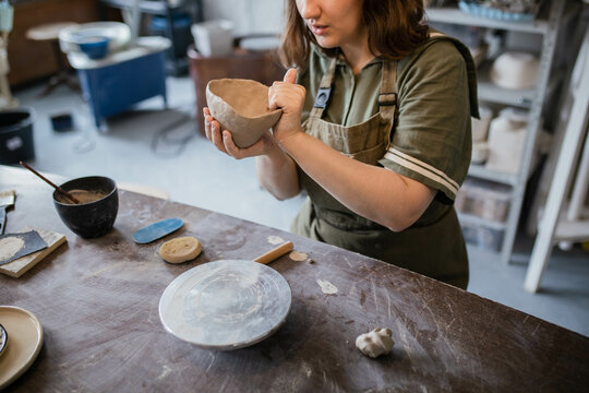 The creative process of creating a clay mug by a female ceramist - Powered by Adobe