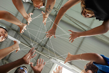 Coworkers joining hands with thread