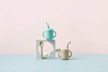 Baby drinking cups with lids and straws.