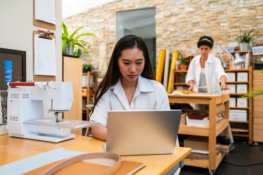 Self-employed asian woman browsing laptop 