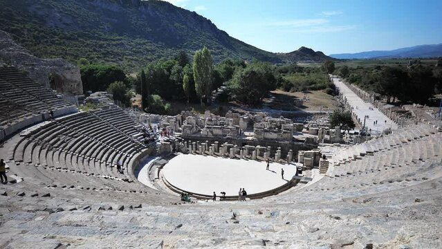 Ephesus ancient theatre landscape view with unidentifiable tourists in the ancient archaeological site of Ephesus, in Selcuk, Turkey.