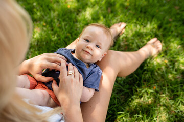 Baby Relaxes In Mother's Lap Outdoors