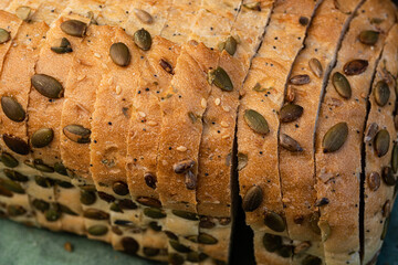 pumpkin seeds, sunflower seeds, sesame seeds, and poppy seeds on sliced loaf of white seeded bread - 532548585