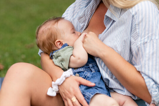 Infant Breastfeeds From Mother While Outdoors 