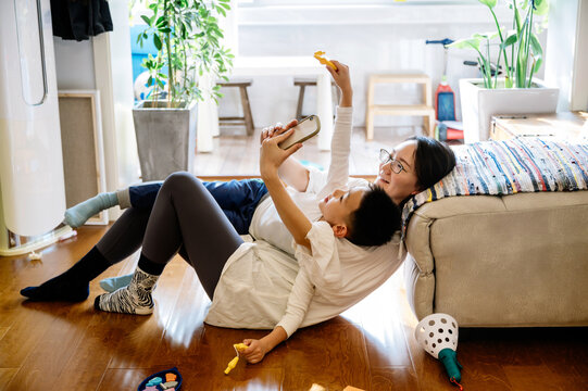 Mother and her toddler boy taking selfie by using cell phone