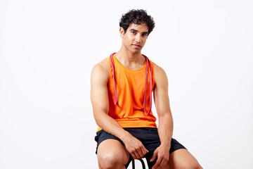 Hispanic sportsman sitting on stool after training