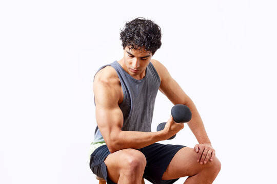 Hispanic sportsman looking at bicep during workout