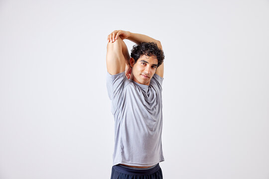 Hispanic sportsman stretching arm during training