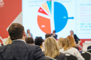 Group of people watching presentation on large screen