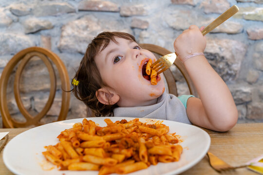 Little girl eating pasta