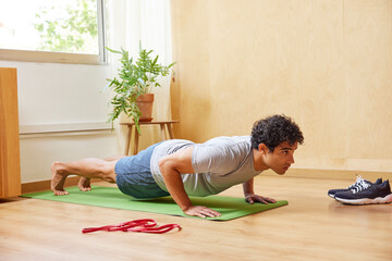 Focused fit Hispanic guy doing Low Push up on mat