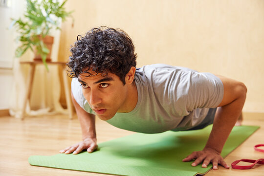 Hispanic male athlete doing push ups on floor