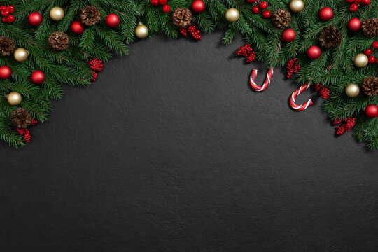 Christmas arch with fir branches, red and golden decor and candy cane on a black background. Happy new year. Greeting card. Copy space, top view, flat lay.