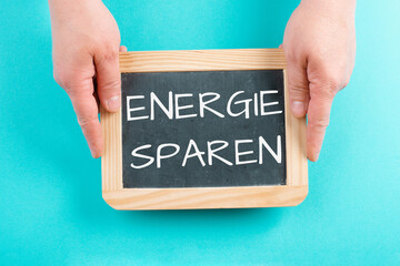 Save energy is standing in german language on the chalkboard, increase of electricity and gas...