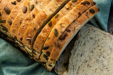 sliced white bread loaf encrusted with pumpkin seeds, sunflower seeds, sesame seeds, poppy seeds - 532551781