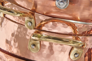 Stacked shiny elegant copper pans.
