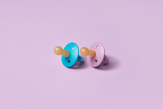 Two blue and pink baby pacifiers.
