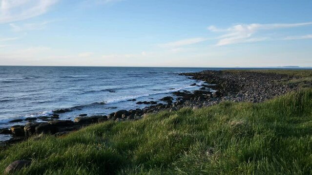 The rocky shoreline of Northern Iceland with small waves crashing
