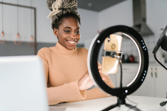 Black woman recording podcast on smartphone