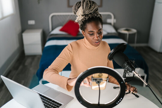 Black woman recording podcast on smartphone