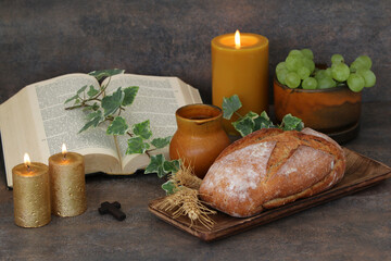 Fototapeta na wymiar Religious still life for Thanksgiving or Holy Communion with bread, candle and bunch of grapes.