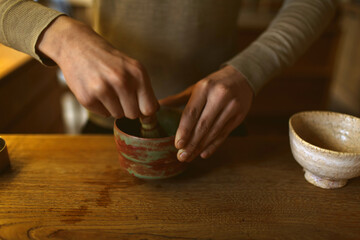 process of making matcha tea. Man's hands