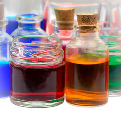 Colored water in small glass jar and bottles