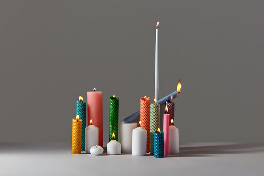 Burning beeswax candles in various shapes.