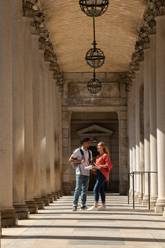 Two Friends University Students review assignment in hallway 