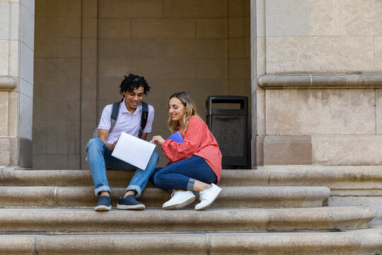 Two cute Friends University Students in conversation  with notebook