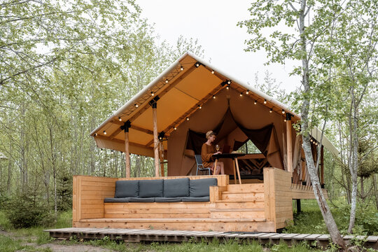 Glamping tent with woman in forest