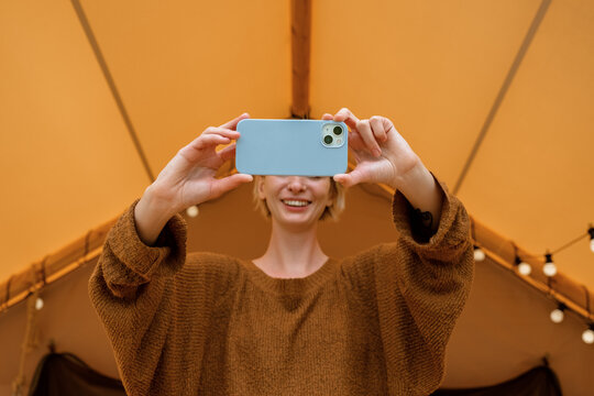 Merry woman taking selfie outside tent