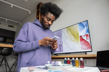 Black male artist taking photo for portfolio at home